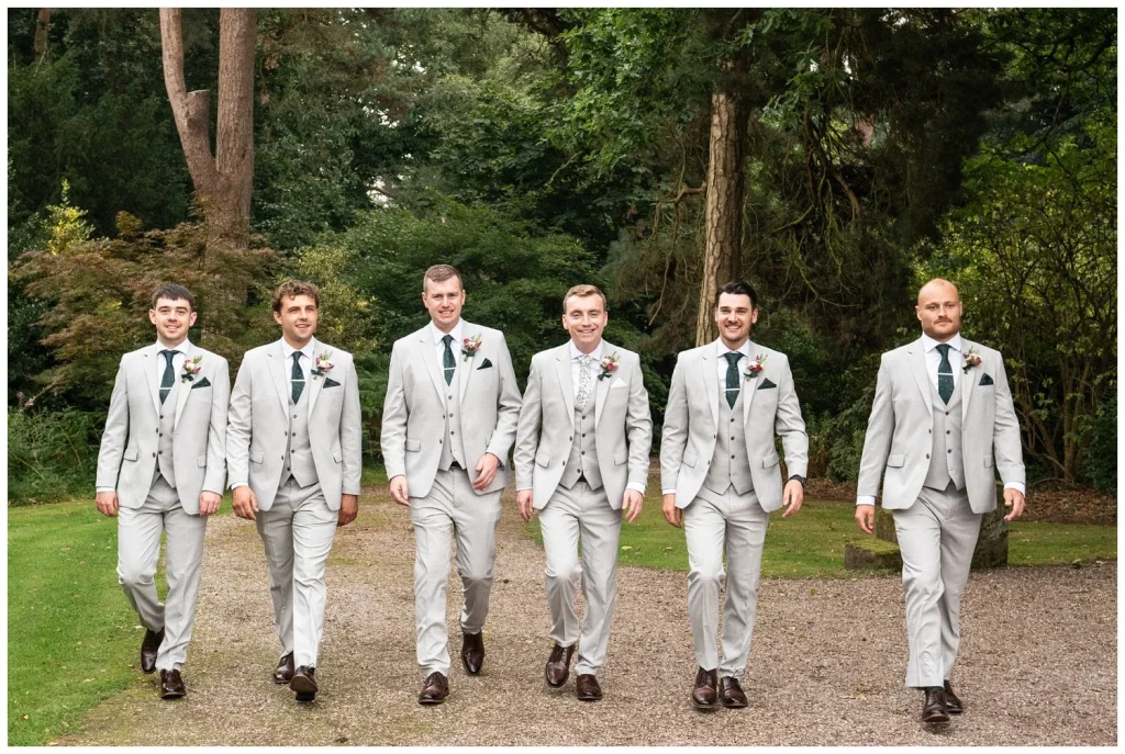 The groom with his groomsmen walking towards the photographer