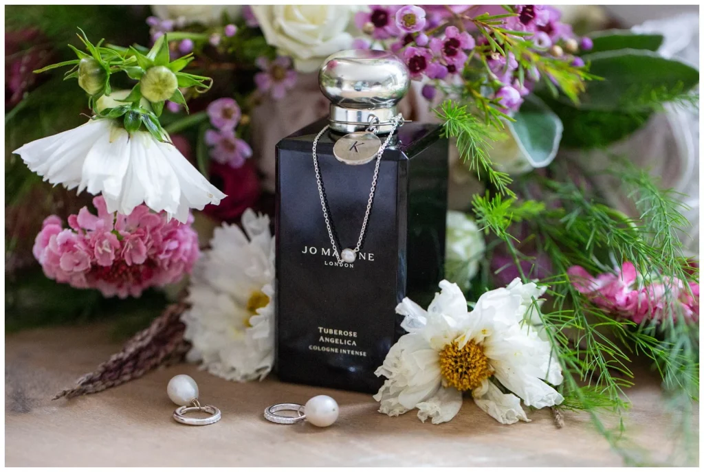 Jo Malone perfume bottle displayed with flowers and jewellery 