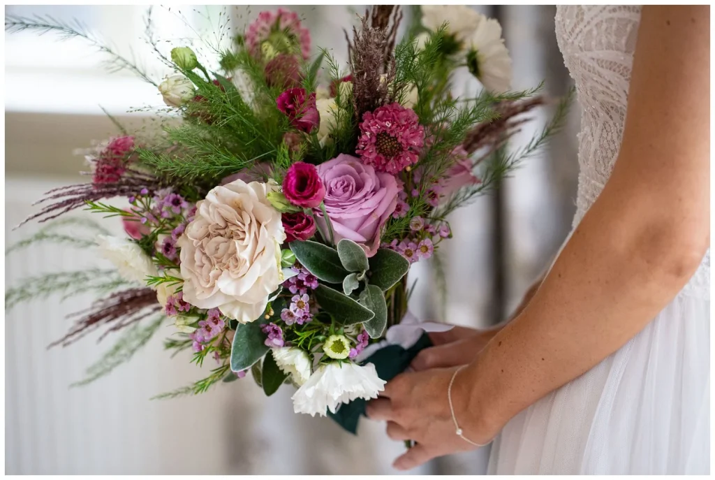 A close image of the brides flowers soft and bright pinks and lots of fine feathery ferns