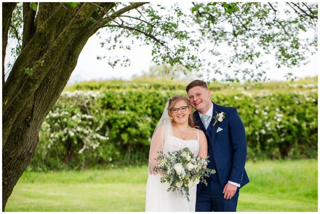 Happy Bride and Groom under a tree at Beeston Manor Lancashire