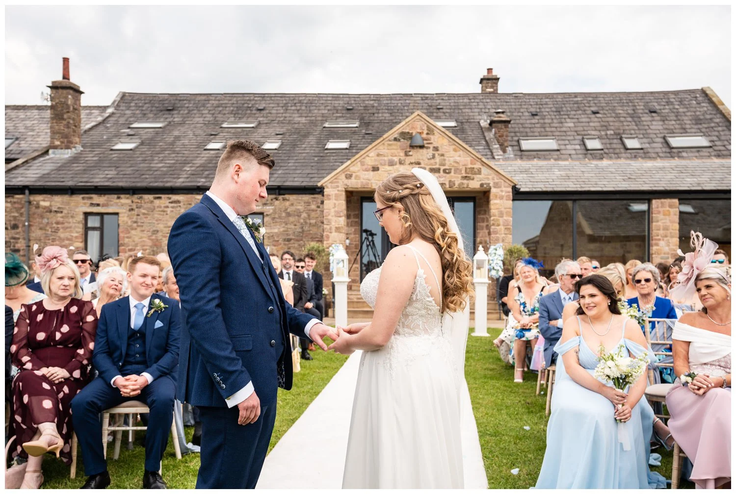 Bride placing ring on grooms finger outdoor ceremony at Beeston Manor Lancashire