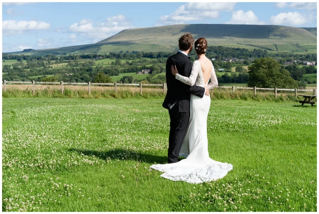 Bride and Groom in a field with the view of Pendle hill