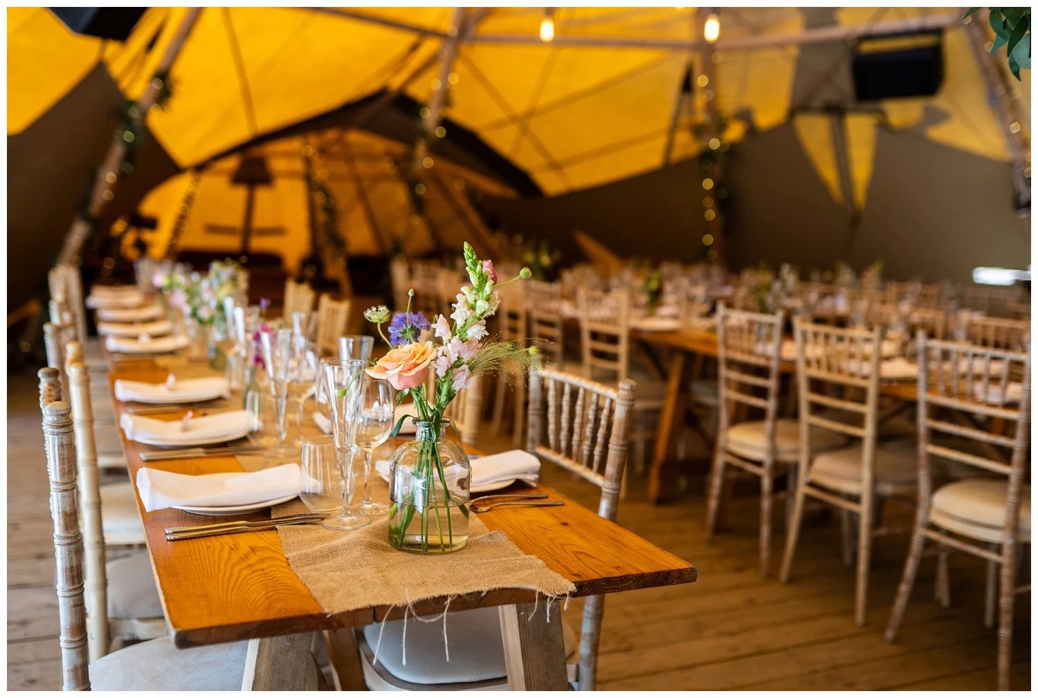 Long trestle tables decorated with wildflowers.